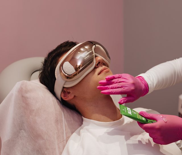 Klient LASERRIX w masującej opasce na oczy na podgrzewanej kozetce przed zabiegiem